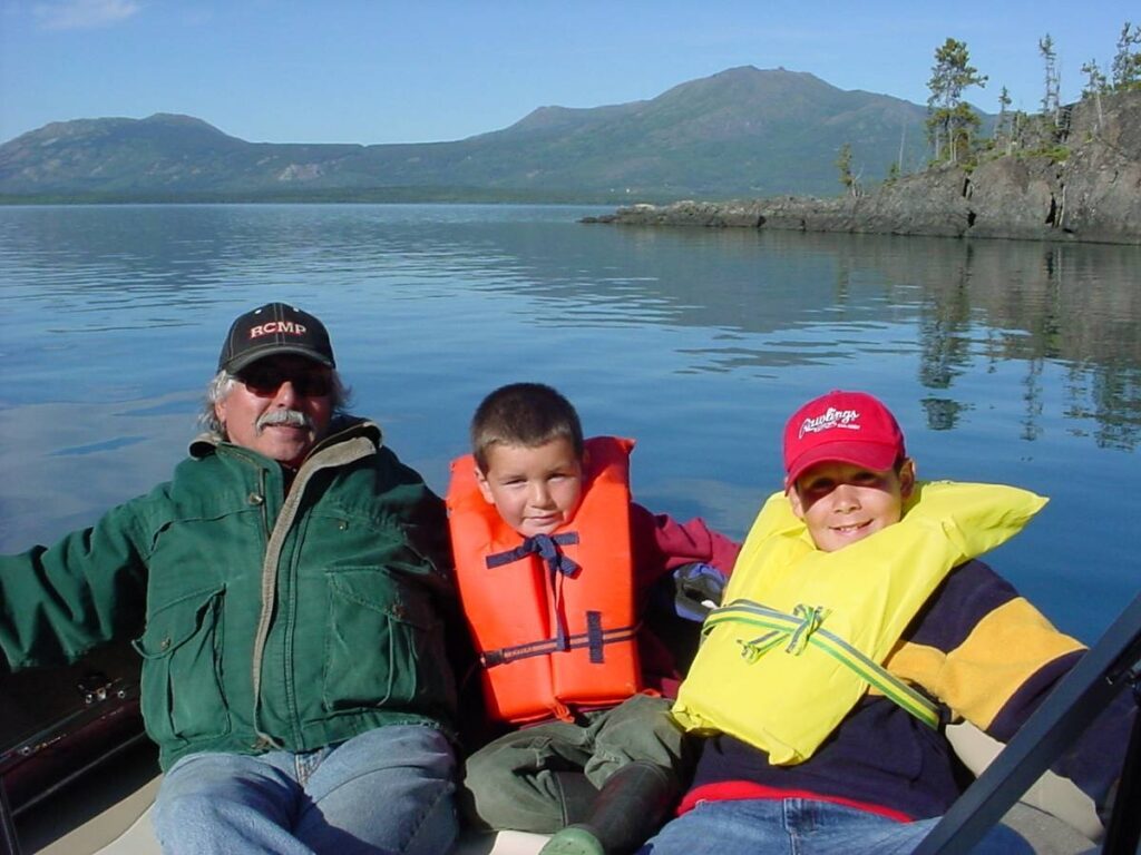 Richard Hardy, left, a residential school survivor and his grandsons McKenzie Barney and Dakota Barney take a boat trip on Atlin Lake, B.C. Photo courtesy of Richard Hardy