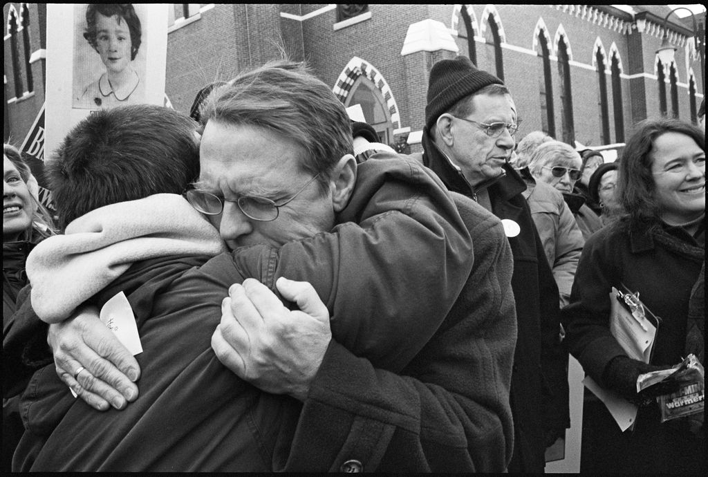 Lisa Kessler, "Solidarity" (2003). Over 200 people at a demonstration demanding that Bishop John McCormack resign, including survivors Kathy Dwyer and David Clohessy, executive director of the Survivors Network of Those Abused by Priests. At right is Rev. Tom Doyle, a priest and canon lawyer whose 1985 report warning the Catholic hierarchy of the potential scope of the sex abuse scandal was ignored, and Anne Barrett Doyle, cofounder of Bishop Accountability. Manchester, N.H., January 2003. ©LISA KESSLER, COURTESY HOWARD YEZERSKI GALLERY