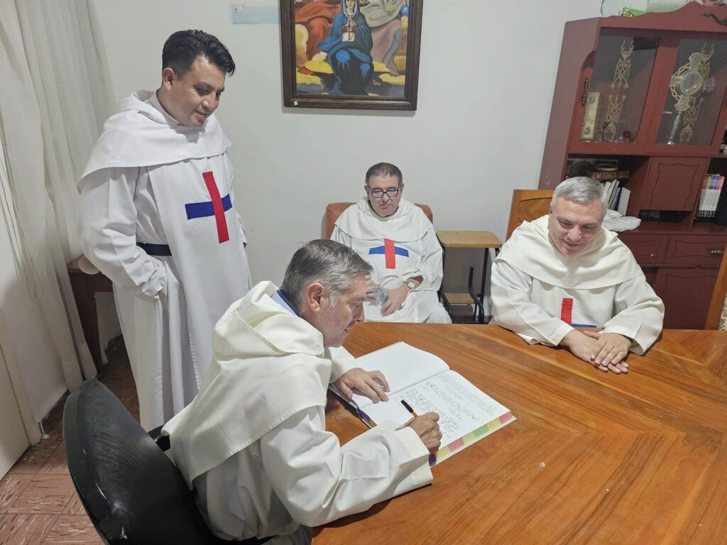 Jacinto (standing) looks as his boss writes on a book at the Foundation.