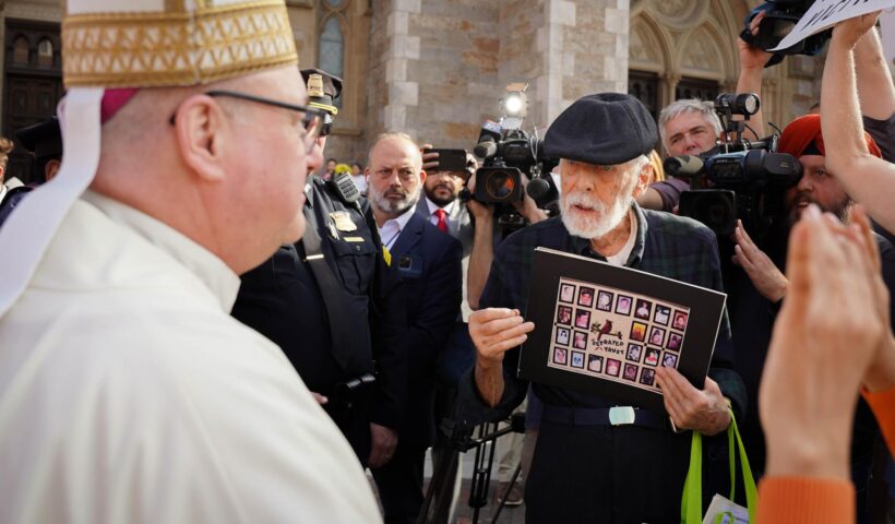 Archbishop Richard Henning talking with protesters gathered outside the Cathedral of the Holy Cross on Oct. 31, 2024 (Yogev Toby / Beacon Staff).