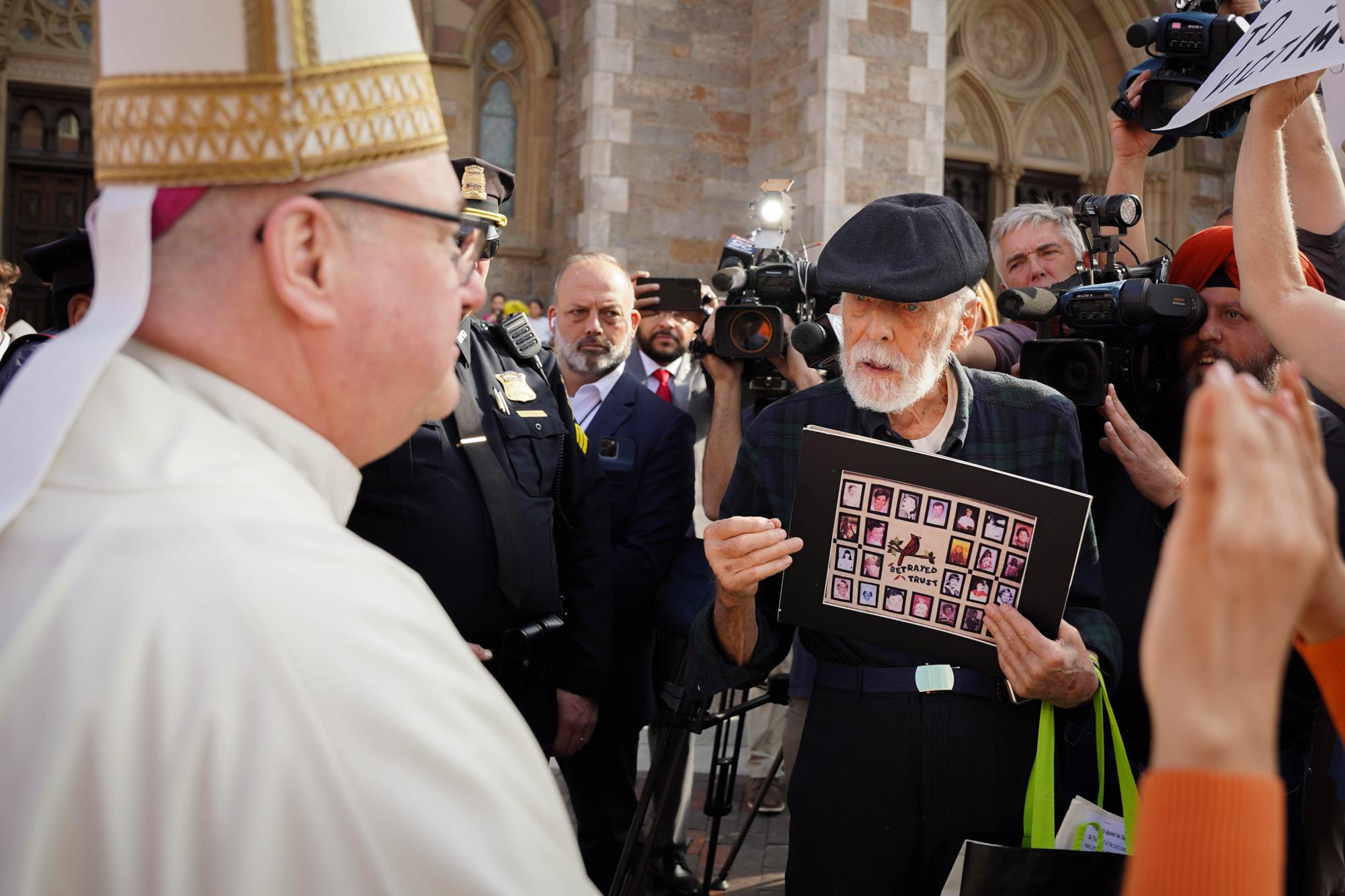 Archbishop Richard Henning talking with protesters gathered outside the Cathedral of the Holy Cross on Oct. 31, 2024 (Yogev Toby / Beacon Staff).