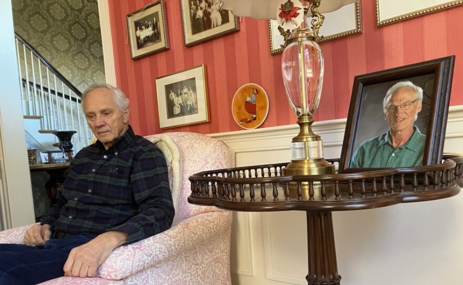 Jim Saviano sits near a photograph of his late brother, Phil Saviano, who was an outspoken critic of those who covered up the abuse of children by Catholic clergy. Investigators from the Massachusetts attorney general's office interviewed Phil Saviano in this room, where he was in hospice, on November 4, 2021. He was a survivor of abuse in the Diocese of Worcester. Nancy Eve Cohen / NEPM