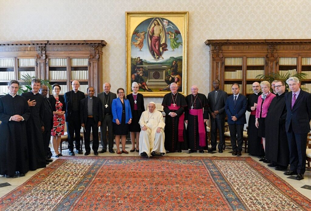 Pope Francis and members of the Anglican-Roman Catholic International Commission pose for a photograph May 13, 2022, in the library of the Apostolic Palace at the Vatican. At the left of the pope is Anglican Archbishop Linda Nicholls, the Anglican primate of Canada and Anglican co-chair of ARCIC; to the right is Archbishop Bernard Longley of Birmingham, the Catholic co-chair of the dialogue. (CNS/Vatican Media)